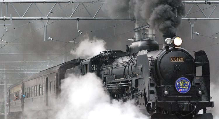 black train on rail and showing smoke